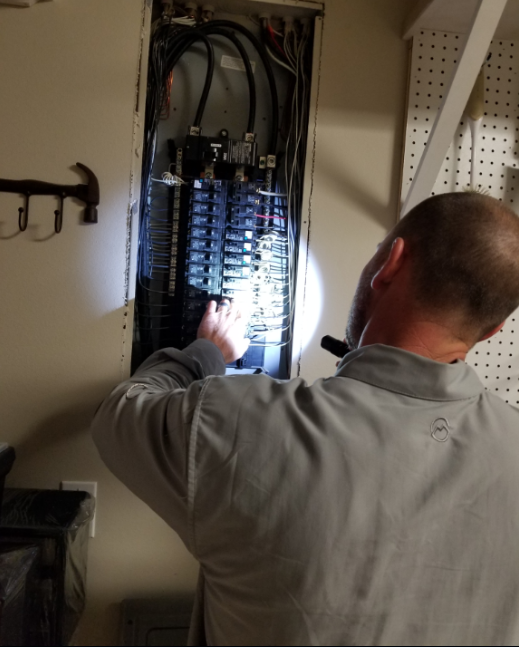 Kelly Olivier personally examining a residential electrical panel during an inspection